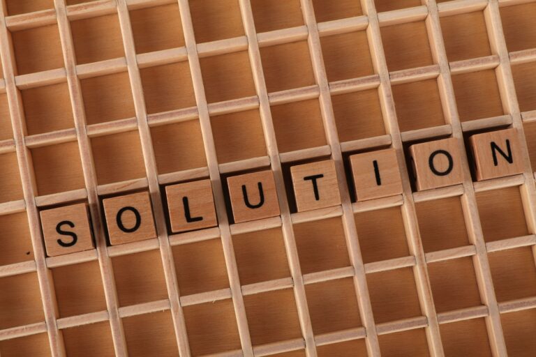 Word tiles spelling 'solution' on a wooden grid background for business concept.