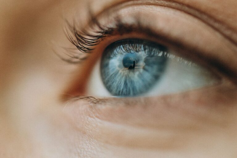 Macro shot of a blue eye highlighting intricate details and eyelashes.